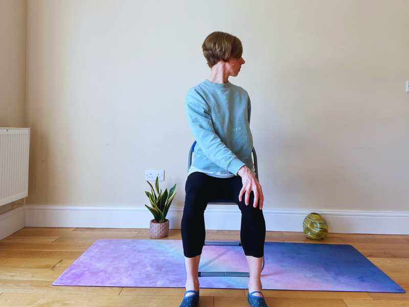Female yoga teacher doing Chair Twist